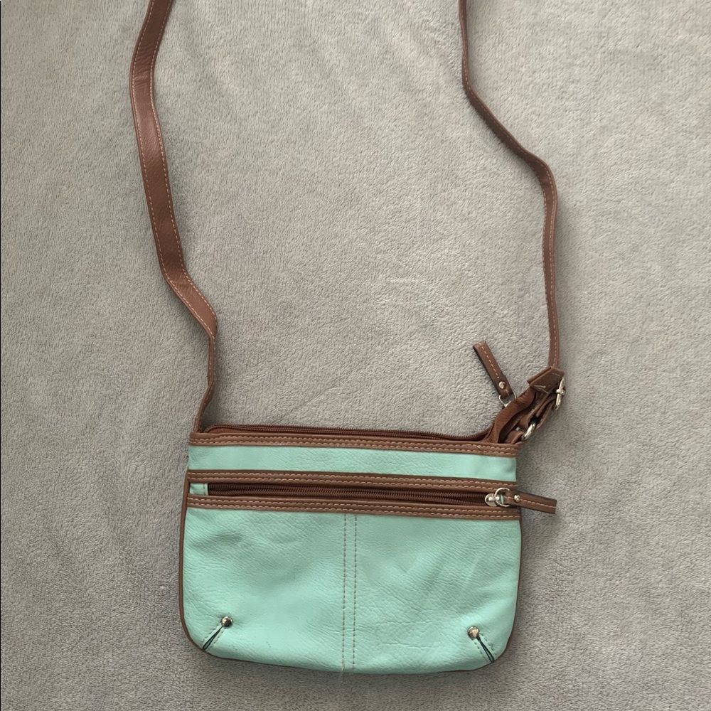 A Crossbody bag that is teal and brown